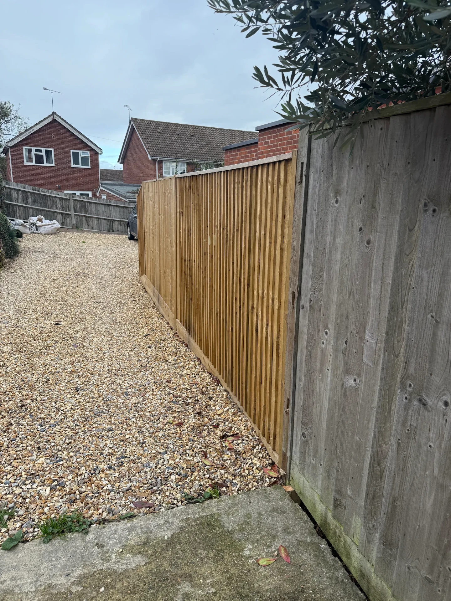 Long run of new timber boundary fencing alongside a gravel driveway