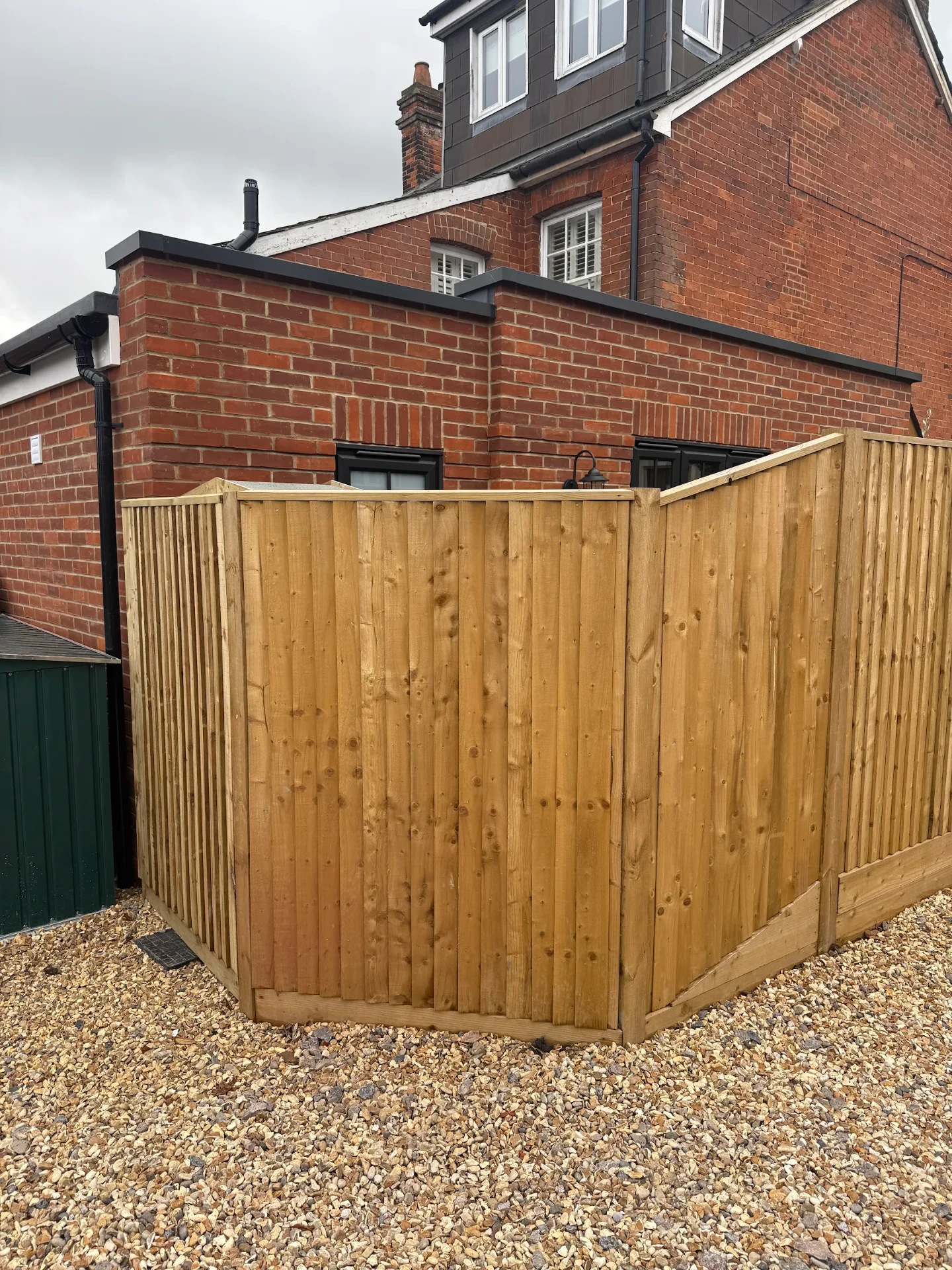 Corner of the new timber fence with stepped panel heights beside the property